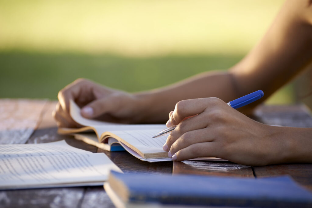 Planning and writing early for US college essays, student working outdoors, The Red Pen