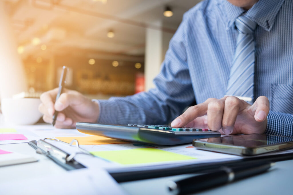 Man calculating finances to become a Certified Accountant, with a focus on UK education - The Red Pen