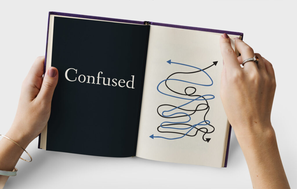 Open book showing the word 'Confused' and a complicated maze illustration, symbolizing confusion in the application process – COVID-19 Effects: Bittersweet Application Results | The Red Pen