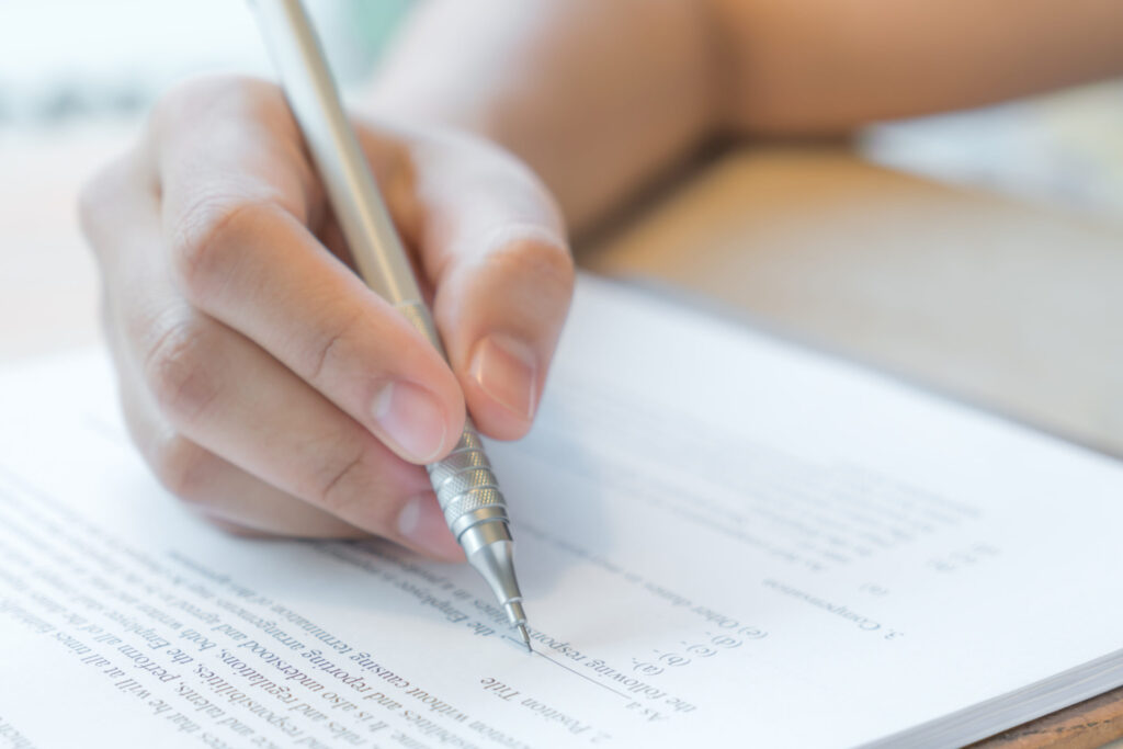 Close-up of student preparing college paperwork without SAT requirement for 2021 admissions – The Red Pen
