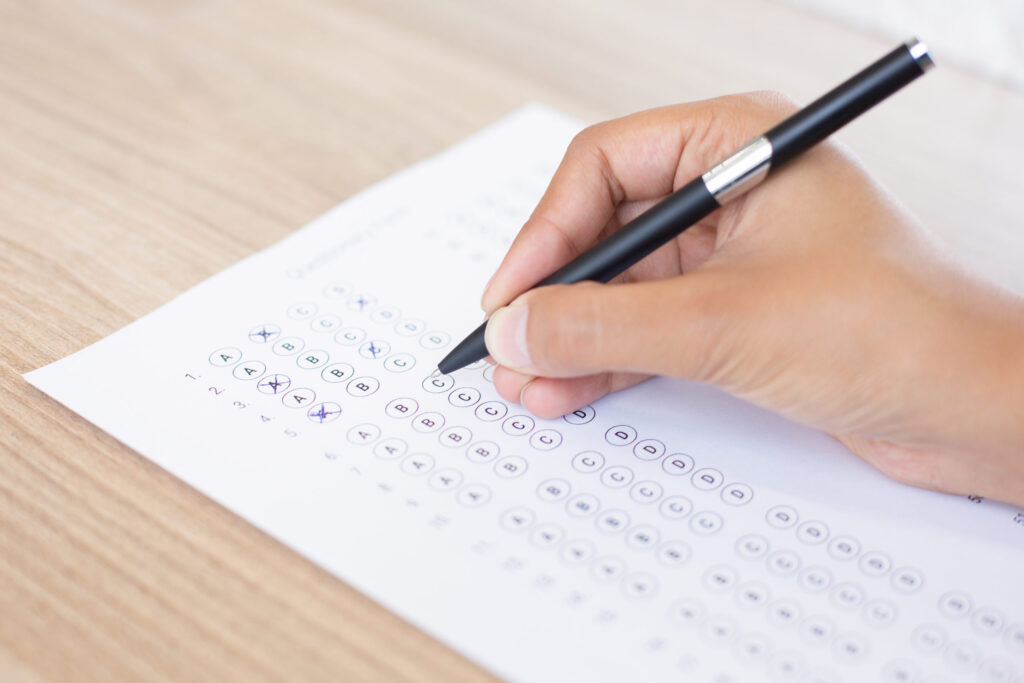 Student marking answers on a standardized test form to compare SAT and ACT options by The Red Pen