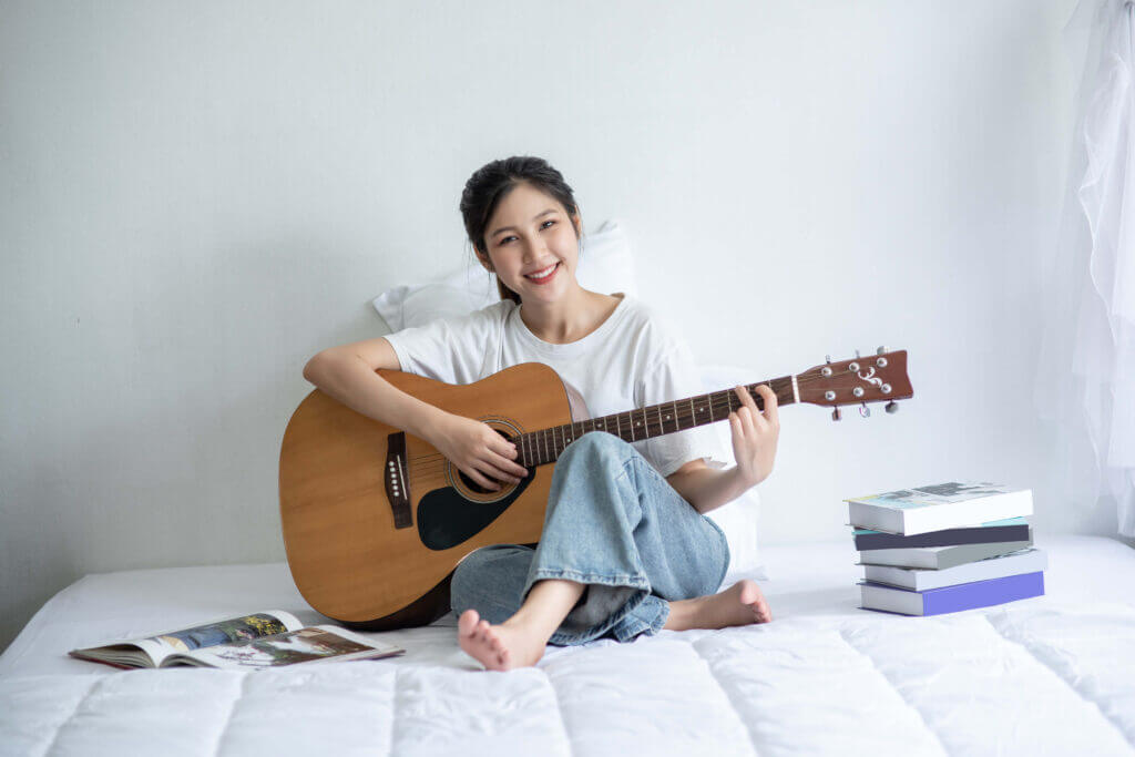 College student playing guitar, showcasing Oberlin's focus on music and arts education by The Red Pen