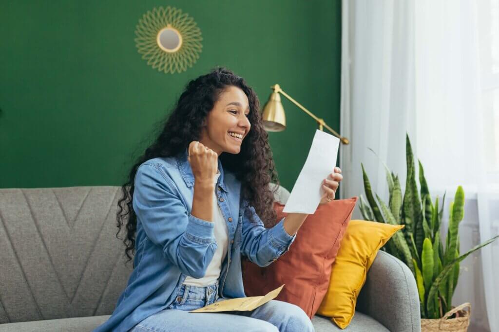 Cheerful woman with test results signaling a return to standardised testing, The Red Pen