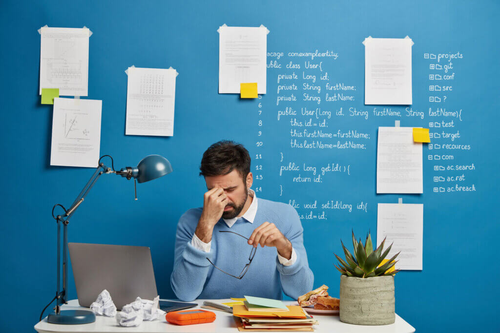 Overwhelmed counselor with paperwork, highlighting strategies to manage burnout in educational settings - The Red Pen