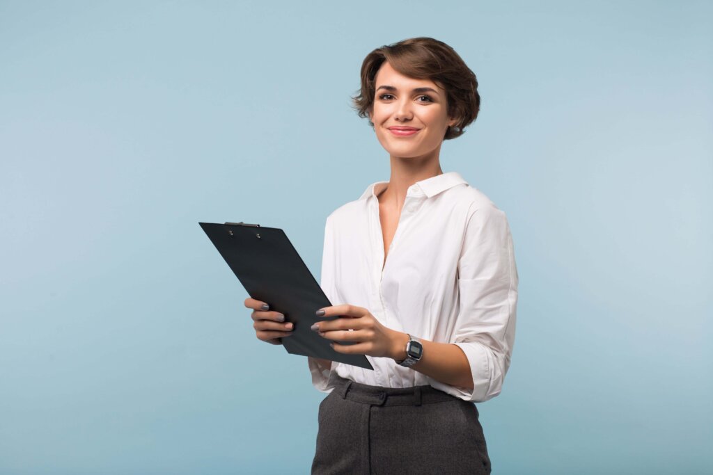 Smiling woman with clipboard exemplifying postgraduate admissions counseling, The Red Pen